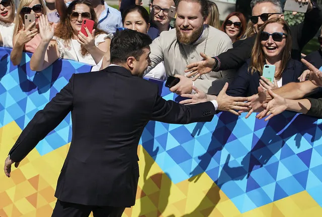 Ukrainian President-elect Volodymyr Zelenskiy greets supporters before his inauguration ceremony in Kiev, Ukraine, Monday, May 20, 2019. Television star Volodymyr Zelenskiy has been sworn in as Ukraine's next president after he beat the incumbent at the polls last month. The ceremony was held at Ukrainian parliament in Kiev on Monday morning. (Photo by Evgeniy Maloletka/AP Photo)
