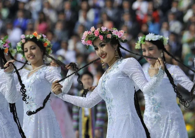 Uzbek dancers in folk costumes perform during the festivities marking the Navruz holiday in Tashkent, Uzbekistan, Wednesday, March 19, 2014. Navruz (“New Year”) dates back to ancient Iranian and Central Asian fire-worshippers who celebrated the spring equinox with dances and ritual food. (Photo by Anvar Ilyasov/AP Photo)