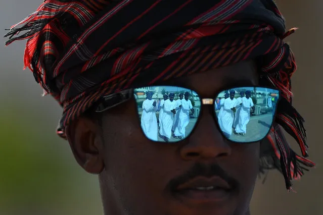 Dancers are reflected in a pair of sunglasses as crowds gather to watch the 10th Tour of Oman cycle race in Muscat, Oman on February 19, 2019. (Photo by Justin Setterfield/Getty Images)