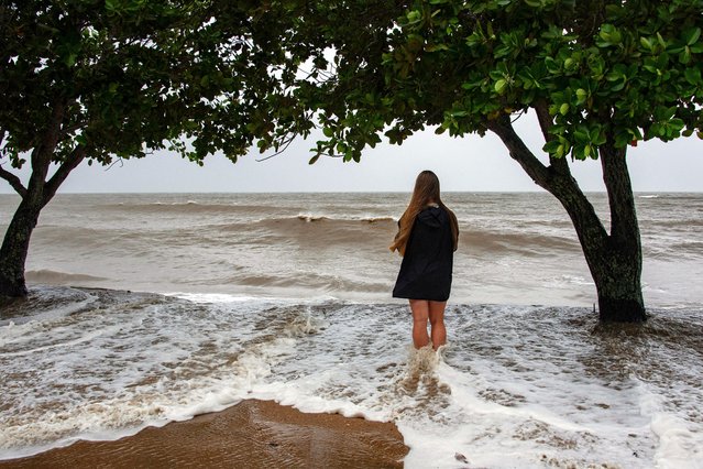 Holloways Beach resident Lisa Methven watches the storm across the Coral Sea as Cyclone Jasper approaches landfall in Cairns in far north Queensland on December 13, 2023. A tropical cyclone was building strength as it rolled towards northeastern Australia on December 13, with authorities warning “life-threatening” floods could swamp coastal regions for days. (Photo by Brian Cassey/AFP Photo)