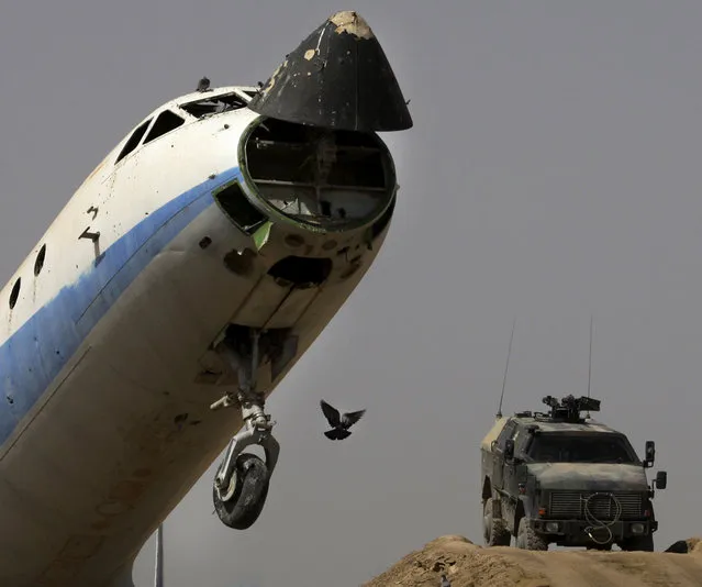 German ISAF soldiers secure an airfield next to a destroyed passenger plane left by the Russians in Kunduz on September 19, 2008. (Photo by Anja Niedringhaus/AP Photo)