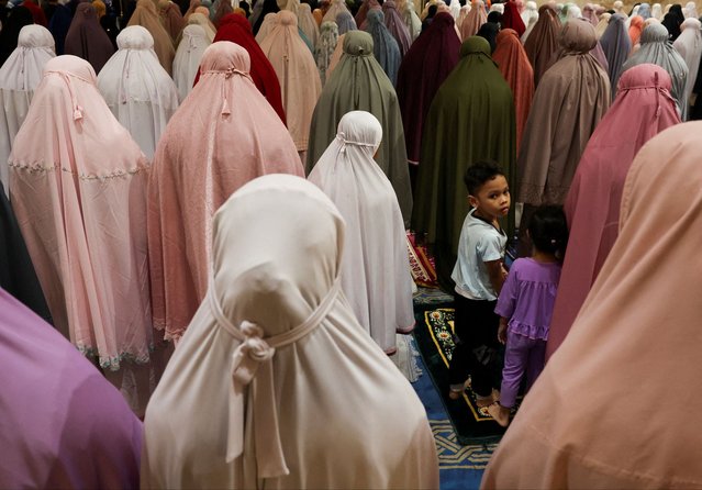 Kids stand amongst Muslim women who are performing the mass prayer of Tarawih during the first eve of the holy fasting month of Ramadan at Seremban, Malaysia, on March 11, 2024. (Photo by Hasnoor Hussain/Reuters)