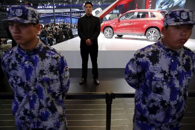 Security personnel guard the Mitsubishi Motors booth as vehicles are presented during the Auto China 2016 auto show in Beijing April 25, 2016. (Photo by Damir Sagolj/Reuters)