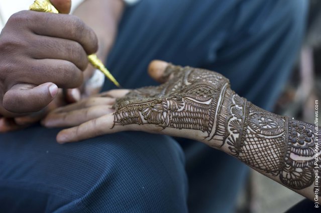 Application of henna or “Mehndi”  to a girls hand in a market in Jaipur, India