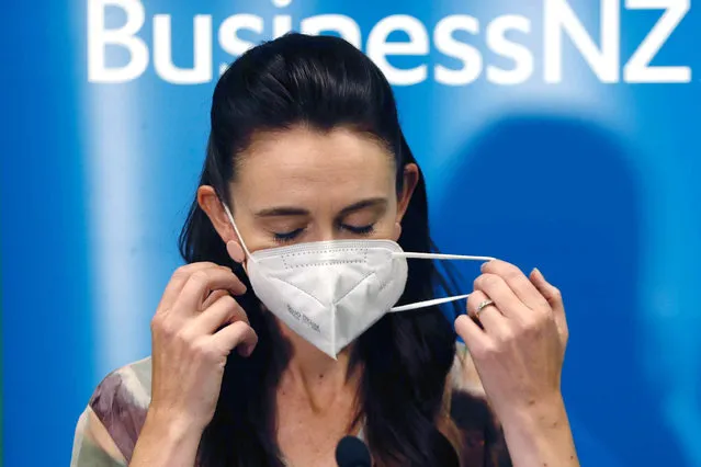 New Zealand Prime Minister Jacinda Ardern removes her mask before she outlines the Government's plans, Thursday, February 3, 2022, that will dismantle its quarantine system and reopen its borders the world. Since the start of the pandemic, New Zealand has enacted some of the world's strictest border controls. (Photo by Dean Purcell/New Zealand Herald via AP Photo)