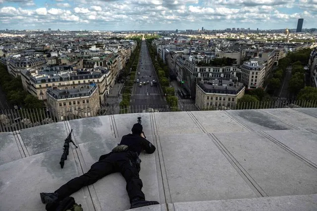 Snipers of the Brigade d'Intervention of the Police take their positions around the Arc de Triomphe to protect the ceremony of the 76th anniversary of Victory in Europe (VE-Day), marking the end of World War II in Europe, on May 8, 2021. (Photo by Martin Bureau/AFP Photo)