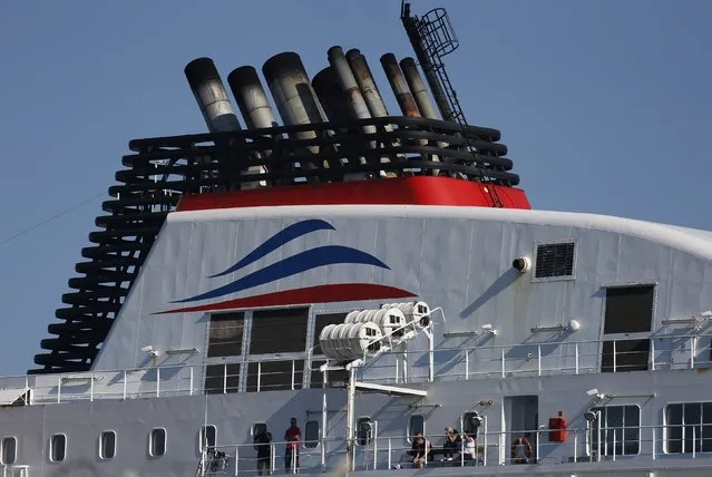 Workers operating on the MyFerryLink car and passenger ferry boats wait for the start of a meeting on the ferry “Le Berlioz” at the harbour of Calais, northern France, June 30, 2015. On Tuesday ferries traffic was halted as striking French ferry workers operating on the MyFerryLink boats renewed a blockade of the northern French port of Calais after a court rejected their bid to extend the service's charter contract with Eurotunnel. (Photo by Vincent Kessler/Reuters)