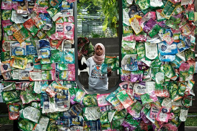 Members of Greenpeace Indonesia display plastic waste from British multinational hygiene and food giant Unilever's products as part of their “Return to Sender” action in front of Unilever’s office in Tangerang, a suburb of Jakarta, on June 20, 2024. (Photo by Yasuyoshi Chiba/AFP Photo)