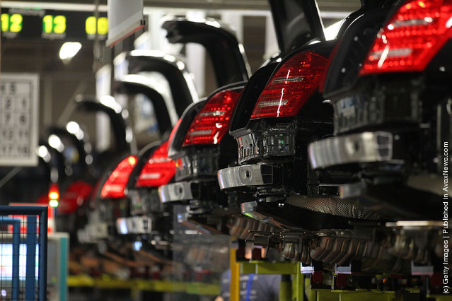 Employees mounts to a Daimler AG Mercedes-Benz S-Class vehicle on the production line