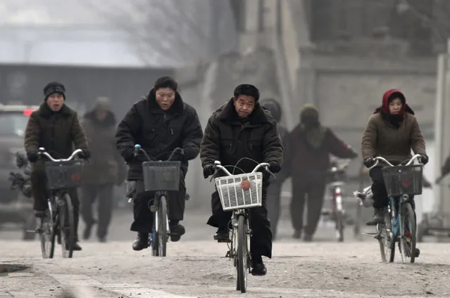 North Koreans ride bicycles at the banks of the Yalu River near the North Korean town of Sinuiju, opposite the Chinese border city of Dandong, December 18, 2013. (Photo by Jacky Chen/Reuters)