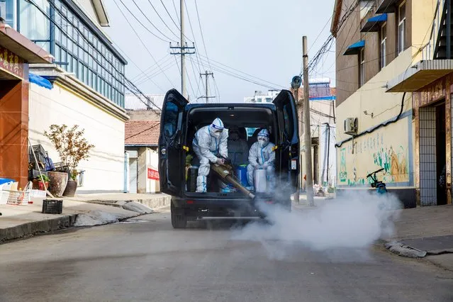 Members of Blue Sky Rescue Team disinfect a residential area on March 20, 2022 in Lianyungang, Jiangsu Province of China. (Photo by Chai Junwei/VCG via Getty Images)