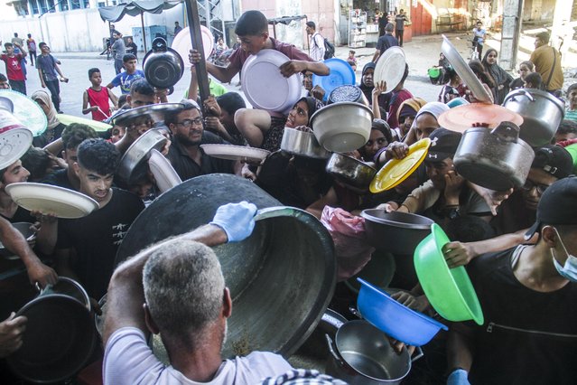 People try to get food relief in the northern Gaza Strip town of Beit Lahia, on July 18, 2024. Workers delivering relief to northern Gaza, in addition to everyday Gaza challenges, must now coordinate with Israeli authorities before passing through a military checkpoint, UN humanitarians said on Thursday. (Photo by Xinhua News Agency/Rex Features/Shutterstock)