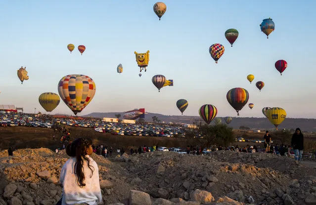 A girl enjoys the hot-air balloons festival in Cajititlan, Jalisco state, Mexico on May 07, 2017. (Photo by Hector Guerrero/AFP Photo)