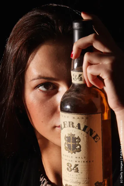 Victoria Kasperovich, an employee at McTear's Auctioneers, views a bottle of Coleraine Single Malt Old Irish whiskey