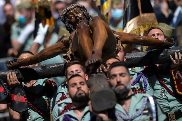 Spanish legionnaires bear a crucifix figure depicting “El Cristo de la Buena Muerte” (Christ of the Good Death) during the “Cristo de Mena” Holy Week procession on April 14, 2022 in Malaga, southern Spain. Christian believers around the world mark the Holy Week of Easter in celebration of the crucifixion and resurrection of Jesus Christ. (Photo by Jorge Guerrero/AFP Photo)
