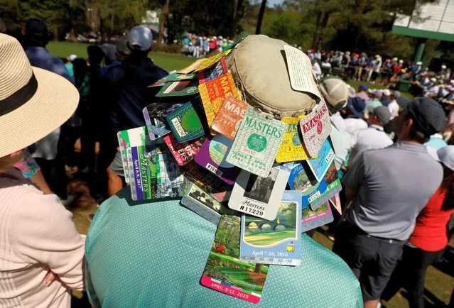 A patron wears a hat covered on Augusta Masters day passes from previous years on the 6th during the final round of The Masters Augusta, Georgia on April 10, 2022. (Photo by Jonathan Ernst/Reuters)