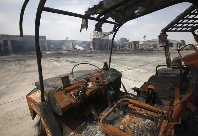 Damaged vehicles are left on the tarmac of Jinnah International Airport, after Sunday's attack by Taliban militants, in Karachi June 10, 2014. REUTERS/Athar Hussain