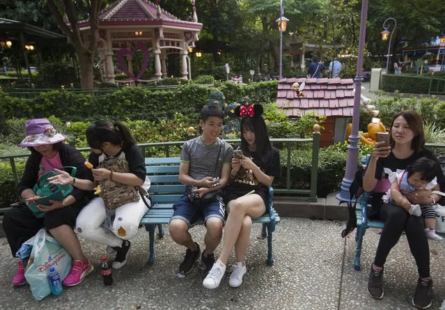 Tourists take a break at Hong Kong Disneyland, in Hong Kong, China, 27 May 2017. The numbers of tourists visiting Hong Kong Disneyland has declined since Shanghai Disneyland opened in June 2016. Shanghai Disney Resort has announced on 19 May that more than 10 million people have visited the park after eleven months of operations, outshining its Hong Kong counterpart which has posted financial losses for two consecutive years. (Photo by Alex Hofford/EFE/EPA)