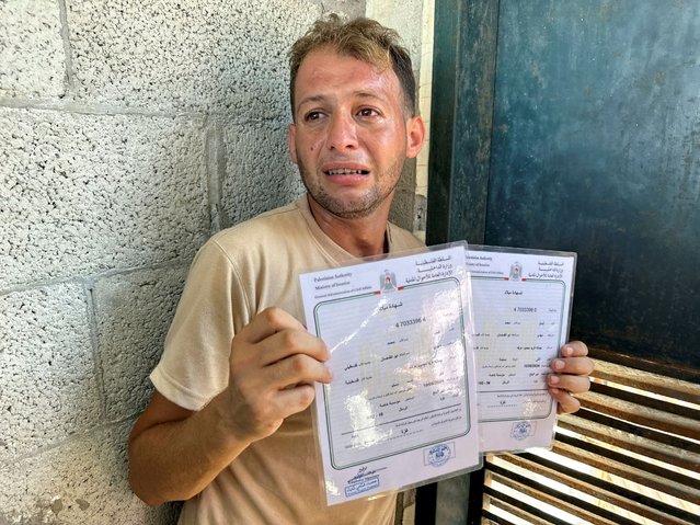 Mohammed Abu Al-Qumsan, whose wife Jumann, and newborn twins Asser and Ayssel were killed in an Israeli strike while he was bringing the twins' birth certificates, according to medics, reacts as he holds the certificates, in Deir Al-Balah in the central Gaza Strip on August 13, 2024. (Photo by Abdullah Al-Attar/Reuters)