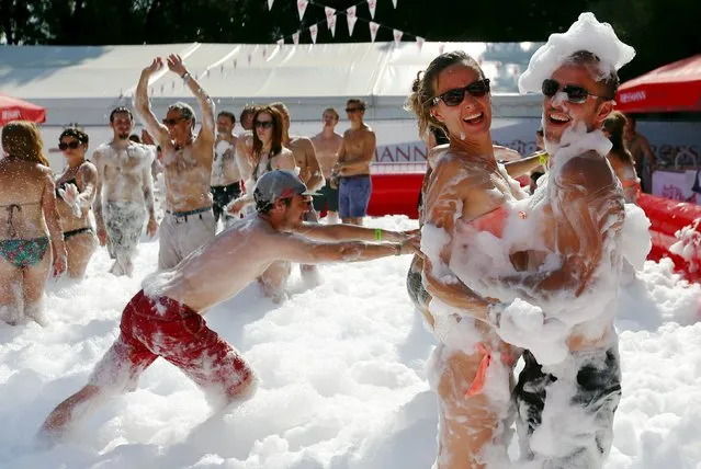 Revellers play with foam during the Sziget music festival on an island in the Danube River in Budapest, Hungary August 12, 2015. (Photo by Laszlo Balogh/Reuters)