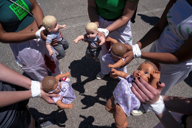 Abortion-rights activists with Rise Up 4 Abortion Rights hold baby dolls while marching to the home of Supreme Court Justice Amy Coney Barrett on June 18, 2022 in Falls Church, Virginia. According to the Rise Up 4 Abortion Rights group, the dolls represent forced births. Abortion-rights protests at the homes of conservative justices have become common since a leaked, draft decision indicated the court may overturn Roe vs. Wade. (Photo by Nathan Howard/Getty Images)