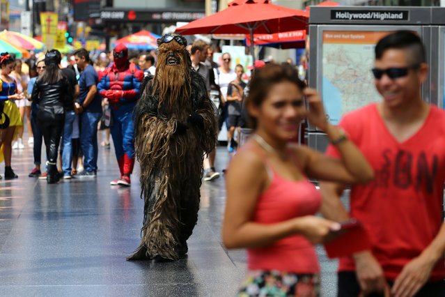 People dressed as characters from movies look to proposition tourists to pay for pictures wth them as they walk along Hollywood Boulevard in Hollywood, California, U.S. August 3, 2017. (Photo by Mike Blake/Reuters)