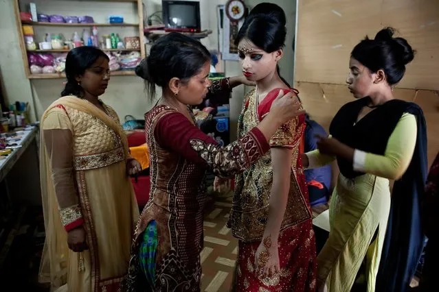 Nasoin Akhter, 15, has her wedding sari wrapped at a beauty parlor on the day of her wedding to a 32-year-old man, August 20, 2015, in Manikganj, Bangladesh. (Photo by Allison Joyce/Getty Images)