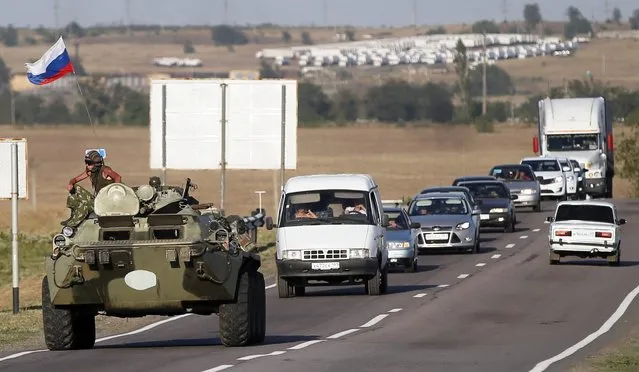 Russian armored vehicles with servicemen atop on a road outside the town of Kamensk-Shakhtinsky in Rostov region, about 30 km from the Russian-Ukrainian border, Russia, 15 August 2014. NATO Secretary General Anders Fogh Rasmussen confirmed media reports that Russian military vehicles have crossed the border into Ukraine, his office says. (Photo by Yuri Kochetkov/EPA)