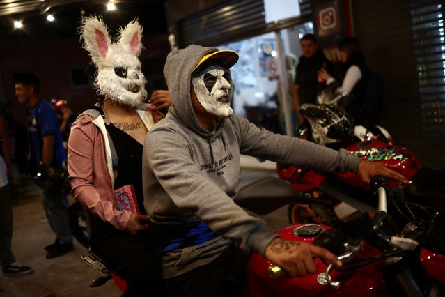 Motorcycle enthusiasts celebrate Halloween wearing masks as they pose for a photograph during a clandestine rally organized weekly, in different places to avoid police intervention, via social media in Ezeiza, on the outskirts of Buenos Aires, Argentina on October 29, 2023. (Photo by Tomas Cuesta/Reuters)
