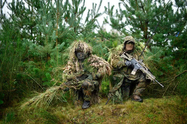 A sniper and his spotter, soldiers of the Bundeswehr, the German armed forces, take part in a simulated attack during military exercises on October 10, 20187 near Munster, Germany. Today's exercises, dubbed “Operation Allied Powers”, involve an infantry tank battalion, air support and artillery, and are part of exercises that have been taking place since September. (Photo by Alexander Koerner/Getty Images)