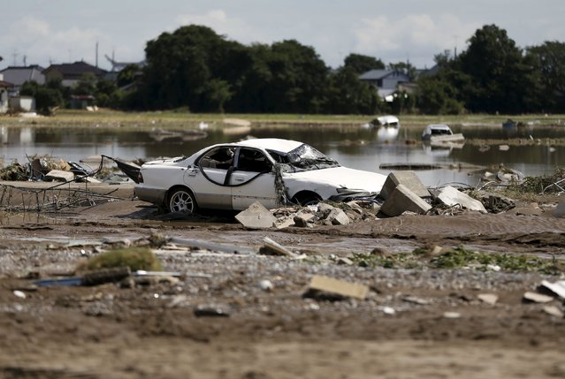 A destroyed car is seen at a residential area flooded by the Kinugawa river, caused by typhoon Etau, in Joso, Ibaraki prefecture, Japan, September 11, 2015. (Photo by Issei Kato/Reuters)