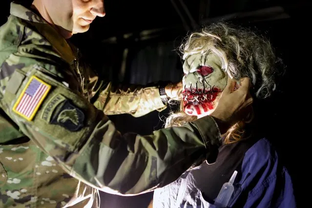A U.S. soldier serving in the NATO peace keeping mission in Kosovo (KFOR) helps his friend to adjust a mask while taking part in a Halloween party at the U.S. military camp Bondsteel in the village of Sojeve, near the town of Ferizaj, Kosovo, 29 October 2017. (Photo by Valdrin Xhemaj/EPA/EFE)