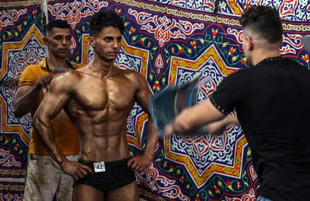 Palestinian contestants take part in a local bodybuilding championship in Gaza City on October 1, 2022. (Photo by Mahmud Hams/AFP Photo)