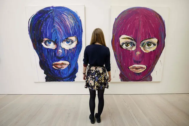 An assistant poses with “p*ssy Icons” artwork by contemporary artist Lusine Djanyan during a press preview for the “Art Riot: Post- Soviet Actionism” and “Inside p*ssy Riot” exhibitions at Saatchi Gallery in central London on November 15, 2017. (Photo by  Tolga Akmen/AFP Photo)