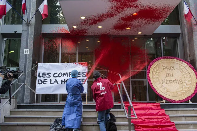 French activists of Attac stage a flash protest outside the French Health Ministry in support of medical workers, in Paris, France, Saturday, June 20, 2020. French hospital workers and others are protesting to demand better pay and more investment in France's public hospital system, which is considered among the world's best but struggled to handle a flux of virus patients after years of cost cuts. (Photo by Rafael Yaghobzadeh/AP Photo)