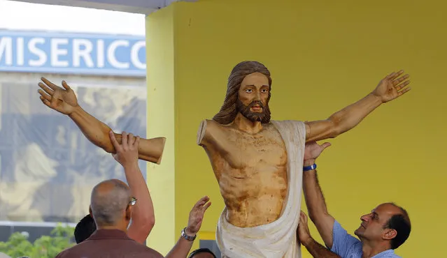 Workers fit an arm onto a Christ statue during preparations of the altar where Pope Francis will celebrate Mass in the Plaza of the Revolution, in Havana, Cuba, Thursday, September 17, 2015. When Francis arrives in Havana on Sept. 19, he'll find his church ministering to more Cubans than at any time since the 1959 revolution that brought Fidel Castro to power. (Photo by Desmond Boylan/AP Photo)