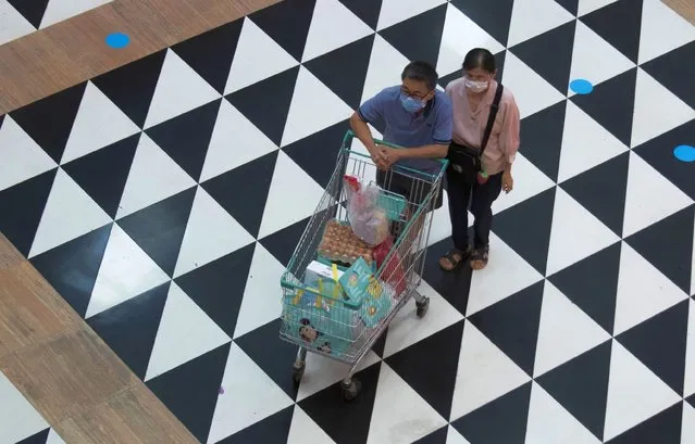 Shoppers wearing face masks to help curb the spread of the coronavirus push their shopping cart at shopping mall in Bangkok, Thailand, Friday, June 12, 2020. The Thai government continues to ease restrictions related to running business in capital Bangkok that were imposed weeks ago to combat the spread of COVID-19. (Photo by Sakchai Lalit/AP Photo)