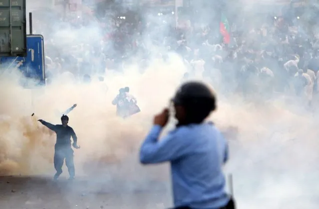 Former Prime Minister Imran Khan's political party Pakistan Tehreek-e-Insaf (PTI) supporters stand amid tear gas as they clash with the police during a protest after Khan suffered a gunshot wound the day before, near Wazirabad, in Islamabad, Pakistan, 04 November 2022. Khan suffered a gunshot wound on 03 November after an unidentified attacker opened fire on a crowded rally led by the politician in Wazirabad, officials said. The former prime minister was leading a long march from Lahore to the capital Islamabad to pressure the government for early elections in the country. (Photo by Sohail Shahzad/EPA/EFE/Rex Features/Shutterstock)