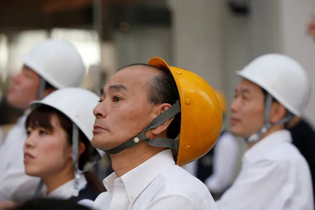 People wearing helmets take part in a drill simulating a 7.2 magnitude earthquake in Tokyo, Japan,  August 26, 2016. (Photo by Kim Kyung-Hoon/Reuters)
