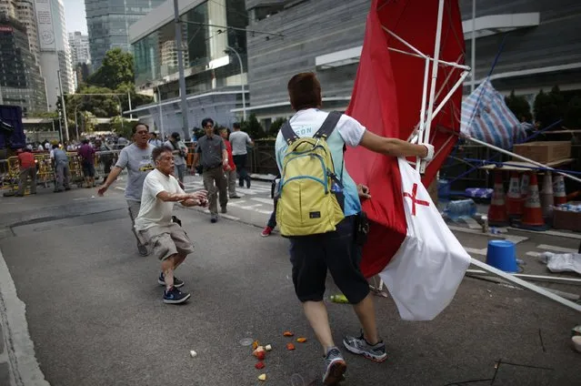 An Anti-Occupy Central protester (R) drags away a tent at the main protest site in Admiralty in Hong Kong October 13, 2014. (Photo by Carlos Barria/Reuters)