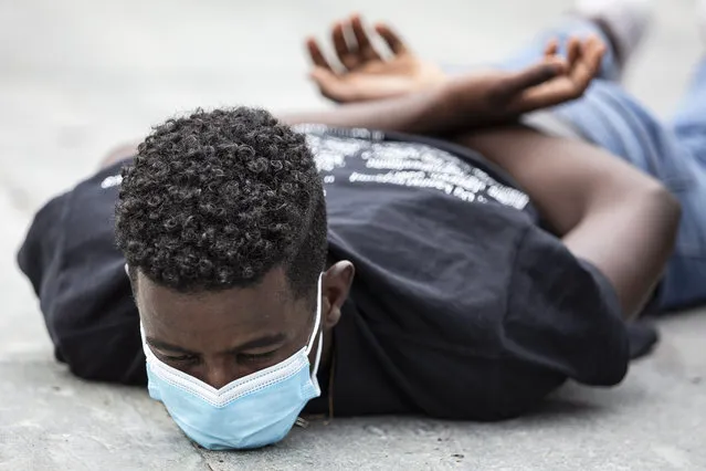 A young man lies on the ground for 8 minutes and 46 seconds during a demonstration against racism in Bern, Switzerland, 11 July ​2020. (Photo by Peter Klaunzer/EPA/EFE)