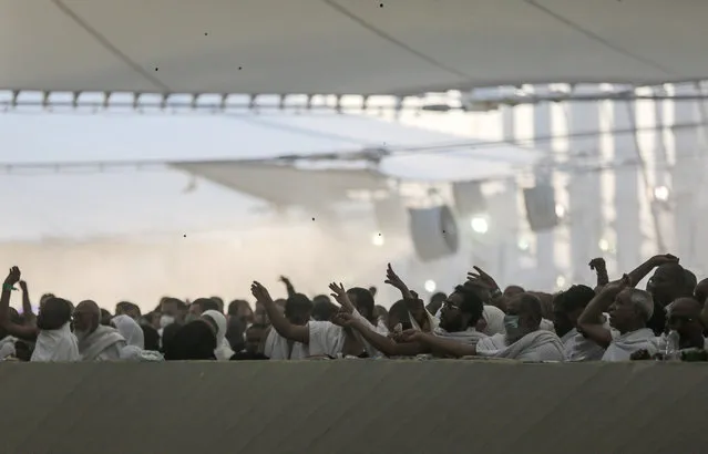 Muslim pilgrims cast stones at a pillar symbolizing the stoning of Satan, in a ritual called “Jamarat”, the last rite of the annual hajj, on the first day of Eid al-Adha, in Mina near the holy city of Mecca, Saudi Arabia, Thursday, September 24, 2015. (Photo by Mosa'ab Elshamy/AP Photo)