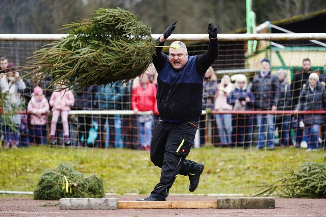 A participant hurls a spruce on the grounds of the Wacker soccer club on January 8, 2024. In Weidenthal, Germany, locals have found a use for redundant Christmas trees by hosting the world Christmas tree throwing championships, now in their 15th year. Participants have to throw a spruce like a javelin, hurl it like a hammer in athletics and manoeuvre it over a high jump. (Photo by Uwe Anspach/dpa via Cover Images)