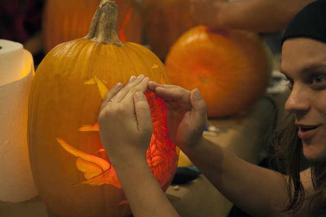 Artist Dima Drjuchin talks to Marc Evan about his pumpkin after inserting a light inside, he is about to go in to refine the details of the design at Cotton Candy Machine in Brooklyn, N.Y. on October 18, 2014. (Photo by Siemond Chan/Yahoo Finance)