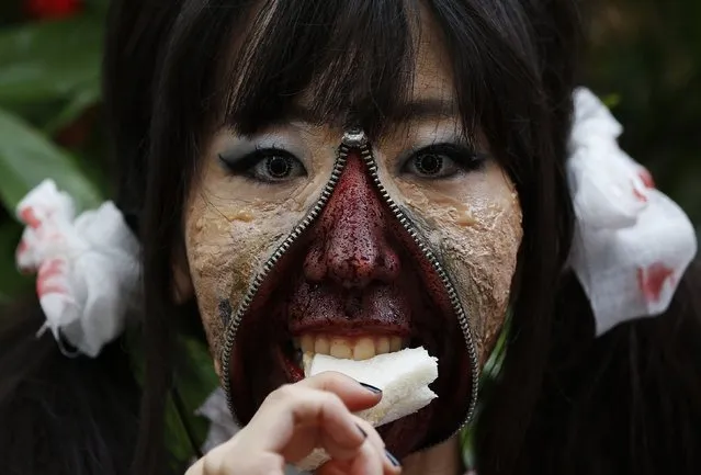 A participant in costume eats a sandwich after a Halloween parade in Kawasaki, south of Tokyo, October 26, 2014. More than 100,000 spectators turned up to watch the parade, where 2,500 participants dressed up in costumes, according to the organiser. (Photo by Yuya Shino/Reuters)