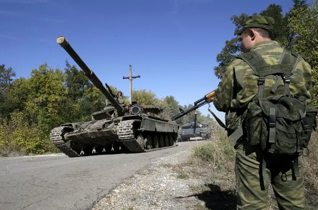 Members of the self-proclaimed Luhansk People's Republic (LNR) ride tanks as they withdraw them further from the frontline outside Luhansk, Ukraine, October 3, 2015. (Photo by Alexander Ermochenko/Reuters)