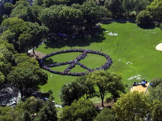 This handout photo provided by FlyNYON shows Yoko Ono and the John Lennon Educational Tour Bus brought out thousands of people to come together and create a human peace sign in Central Park in New York on October 6, 2015. (Photo by AFP Photo/FlyNYON)