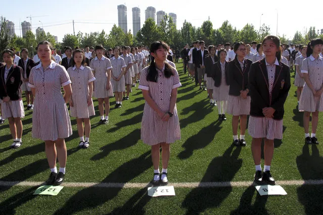 In this August 31, 2016 photo, Chinese student gather on a field as they attend the opening ceremony of the Haileybury College's Chinese campus in northern China's Tianjin Municipality. International schools from outside China are booming thanks to growing demand from Chinese parents seeking different pathways for their children to college abroad. Top prep schools are opening campuses in China and catering to students who want to go to university in the West. Getting into China’s best public high schools can be monumentally difficult and many parents are opting to pay for what they see as a less stressful and more enriching experience at an international school. (Photo by Nomaan Merchant/AP Photo)