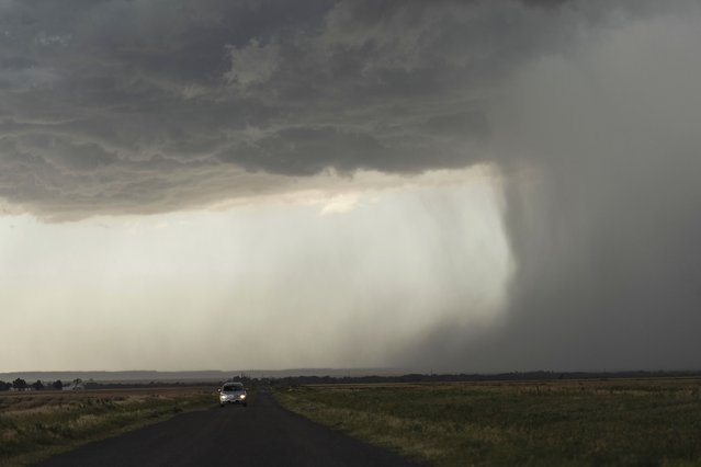 A car moves away from an approaching storm with a rain shaft during a Project ICECHIP operation on Tuesday, June 3, 2025, near Tipton, Okla. (Photo by Carolyn Kaster/AP Photo)