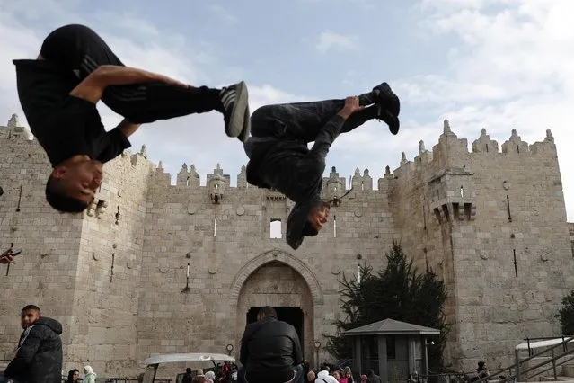 Two men perform parkour moves before the Damascus Gate of Jerusalem's Old City, 12 January 2023. (Photo by Atef Safadi/EPA/EFE/Rex Features/Shutterstock)